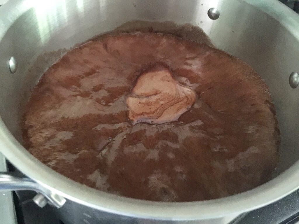 A pot of melted chocolate mixture simmering on the stove.
