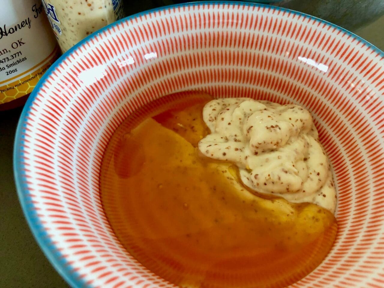 A bowl containing honey and mustard, ready to be mixed for the honey mustard sauce.