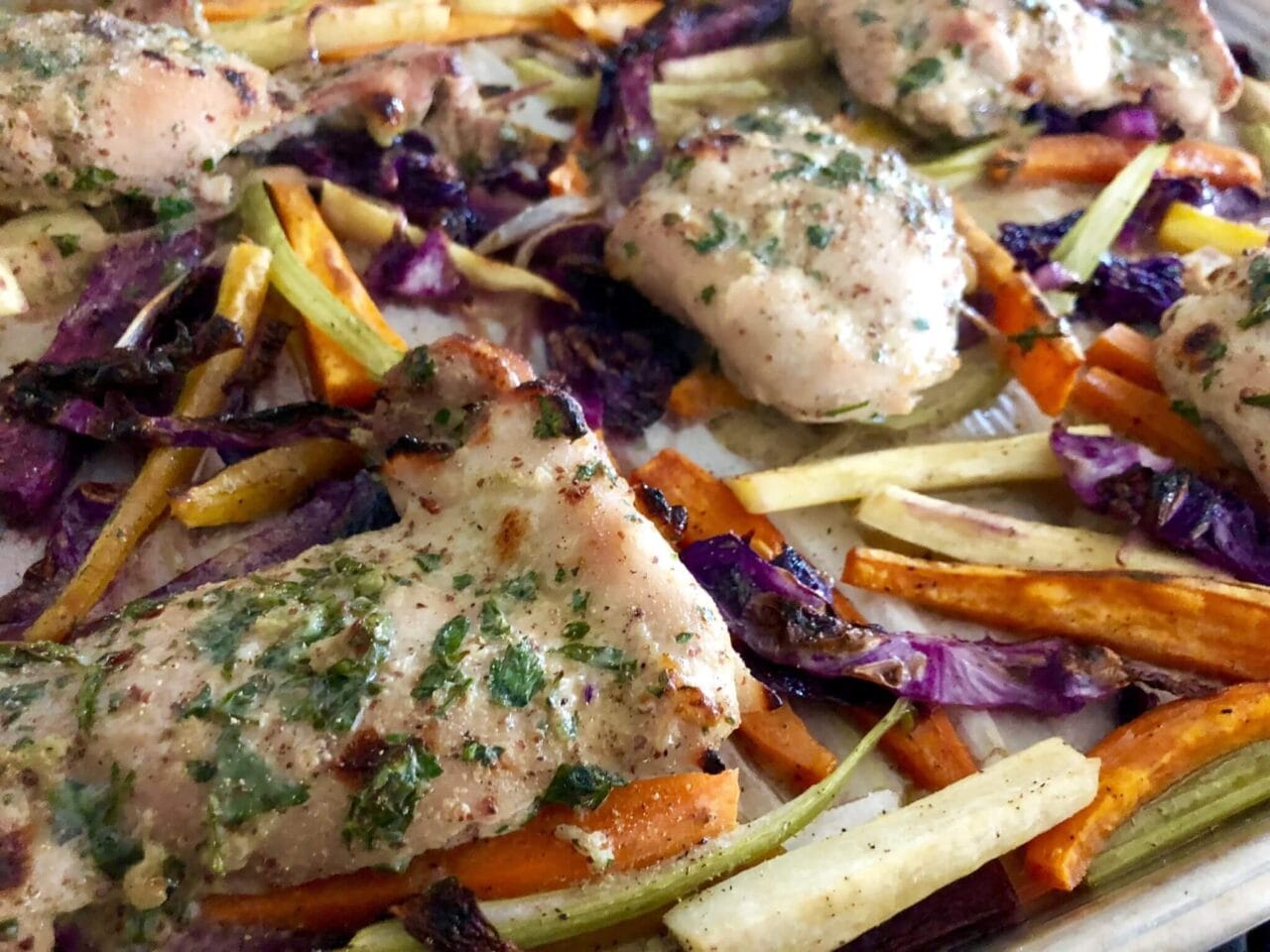 Roasted honey mustard chicken and root vegetables on a sheet pan, freshly out of the oven.