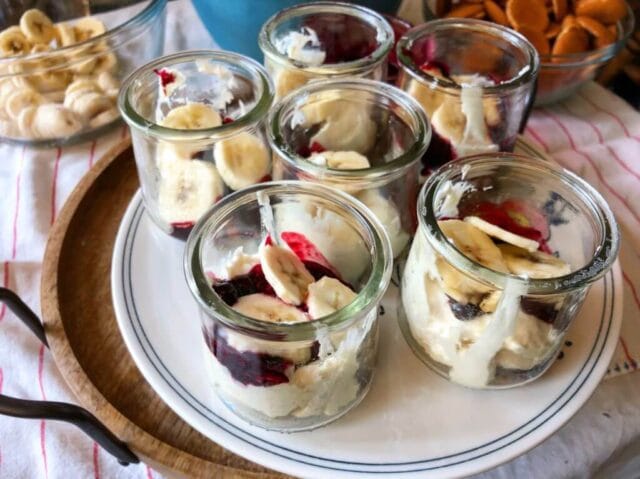 A tray with six glass jars of desserts.