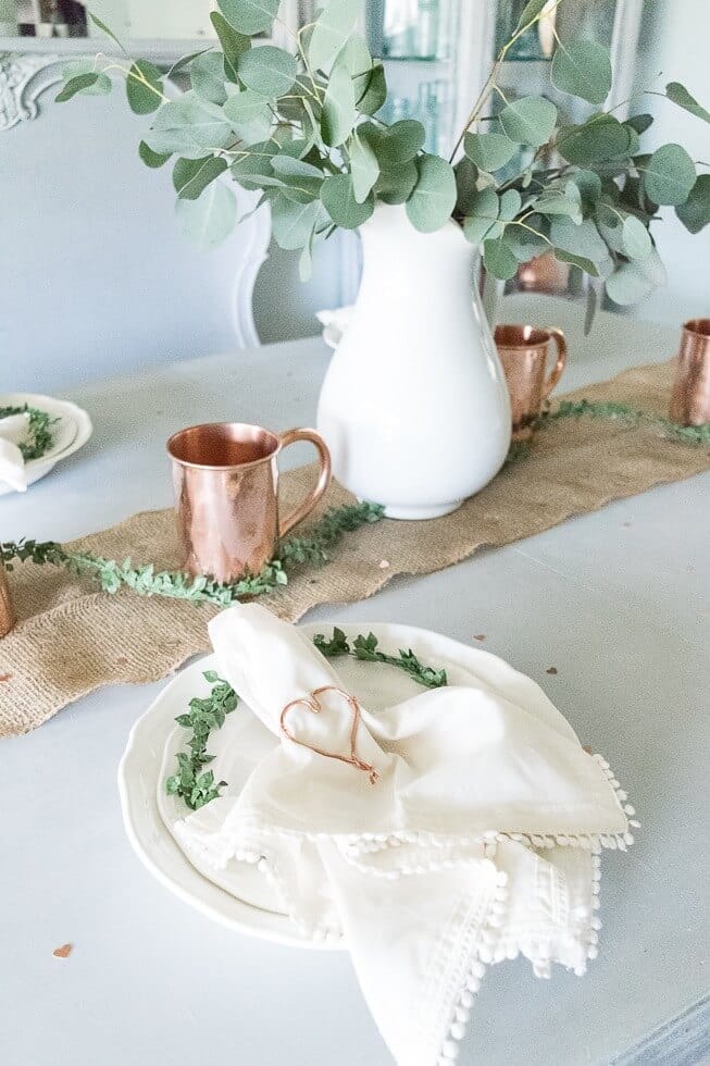 a table setting with a diy copper wire heart napkin holder
