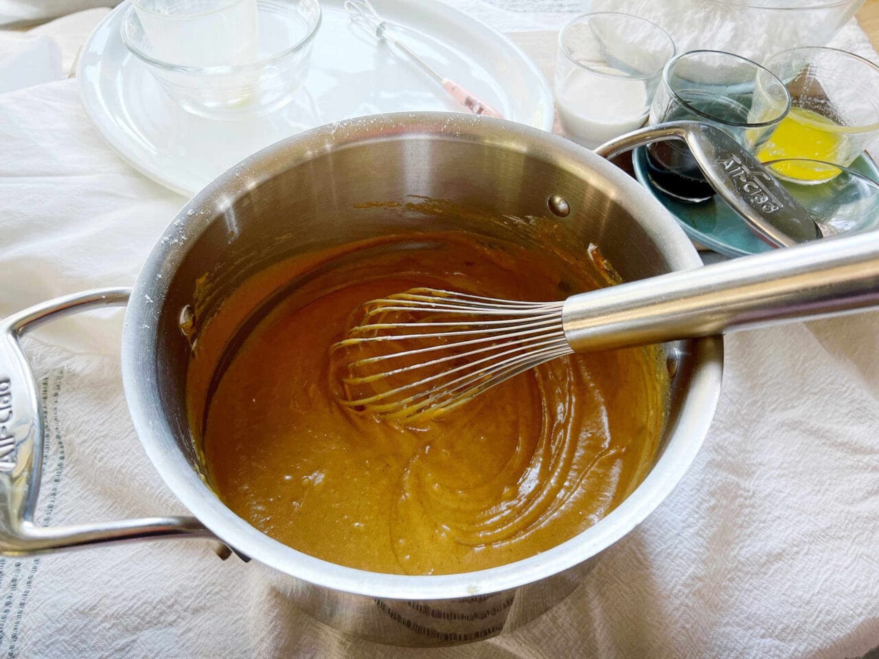 Smooth pumpkin batter being whisked in a pot.