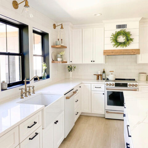 Bright white kitchen with farmhouse sink and white cabinets.