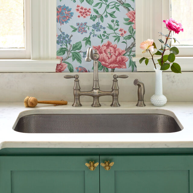 A stainless rectangular undermount sink in a classic kitchen.