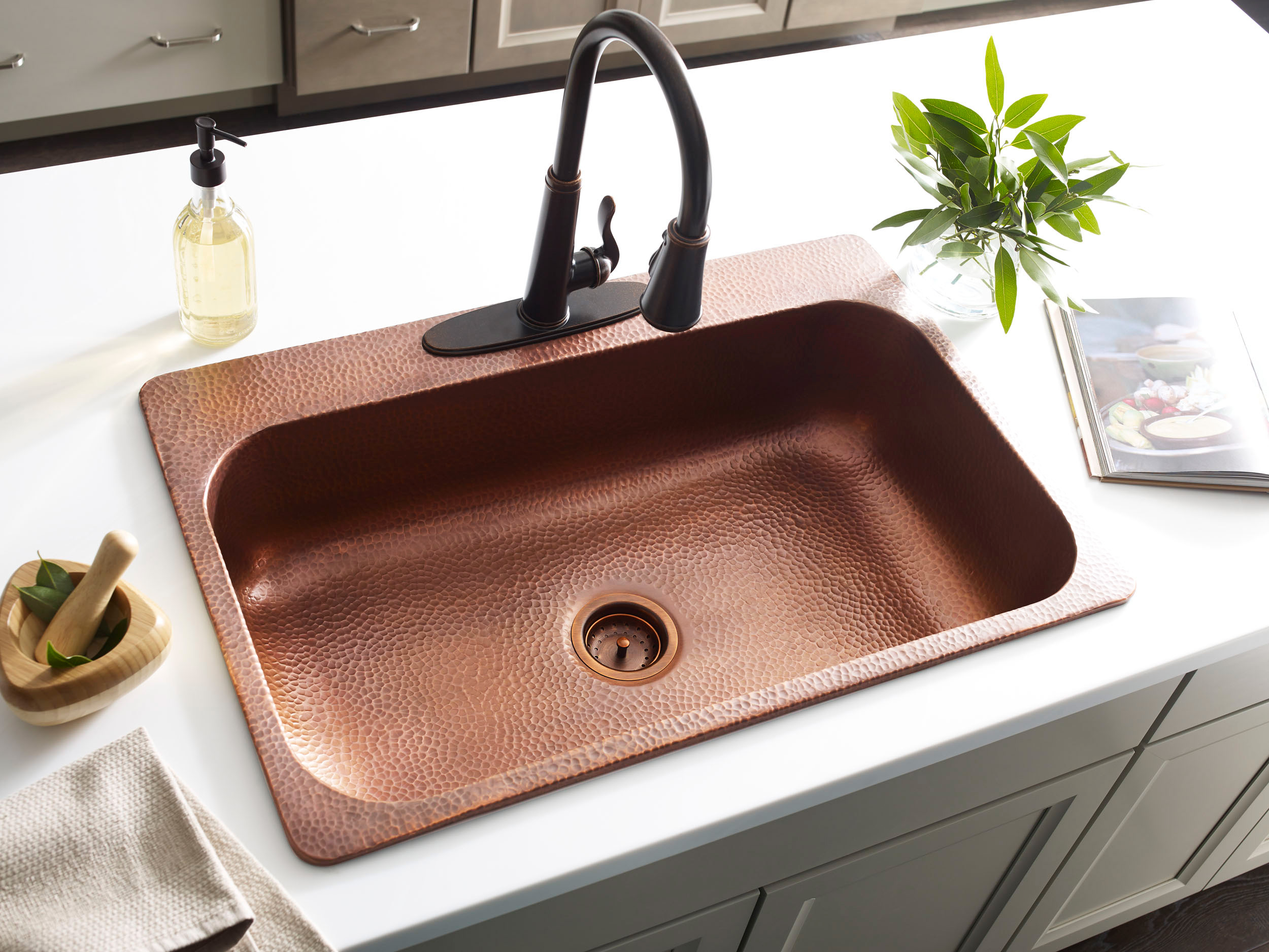 A copper rectangular drop-in sink in a modern farmhouse kitchen.