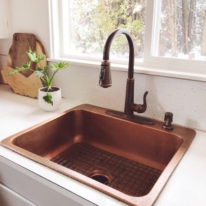 A copper rectangular drop-in sink in a cabin kitchen.