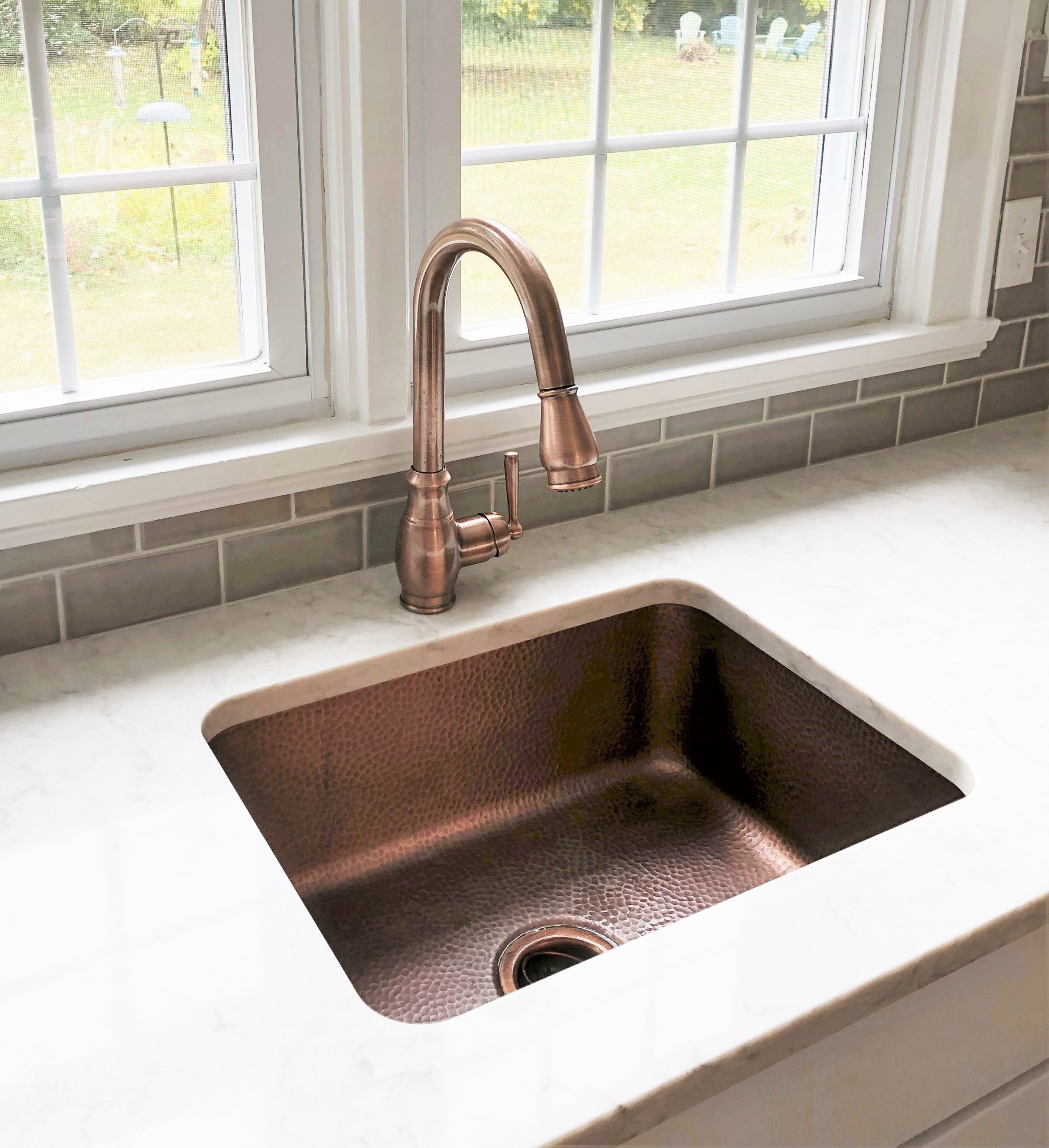 A copper rectangular undermount sink in a home kitchen.