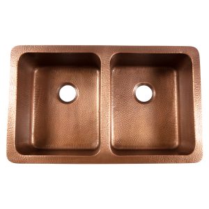 A copper rectangular undermount double basin farmhouse sink.