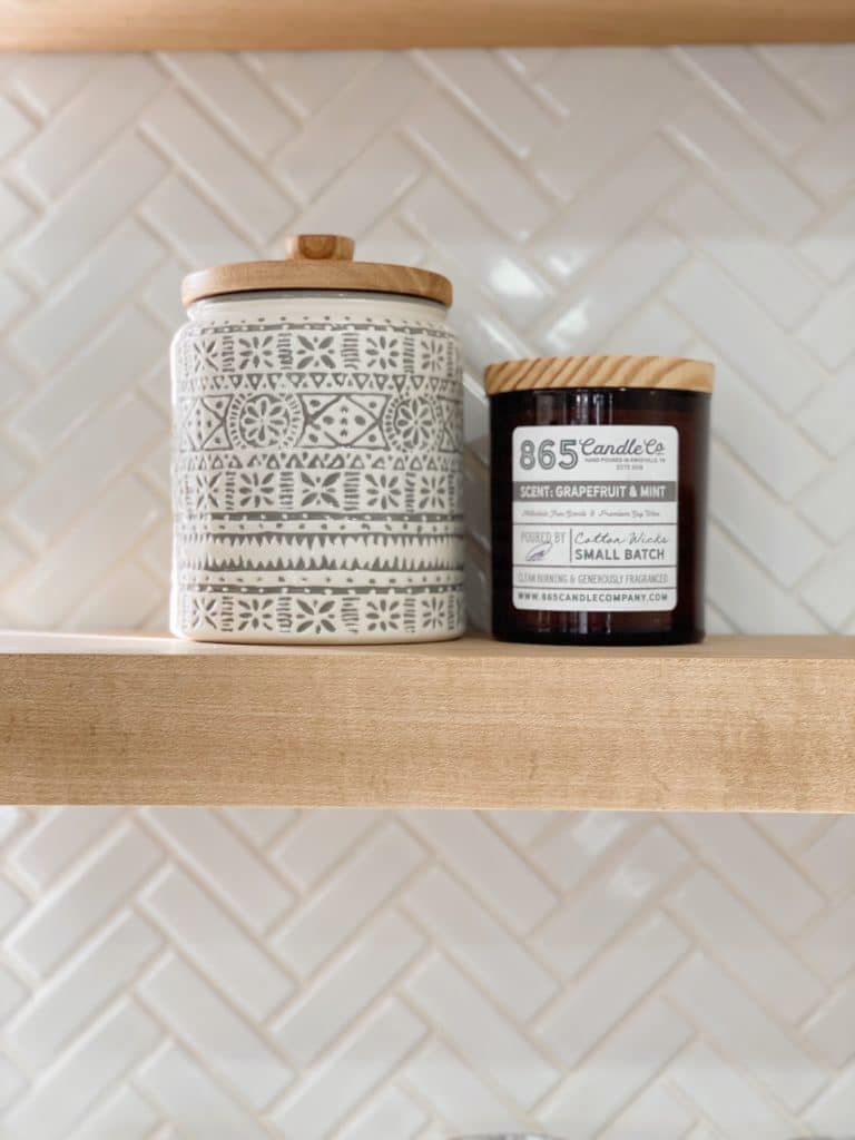 Two decorative jars, one with a gray and white geometric pattern and the other labeled "865 Candle Co" .