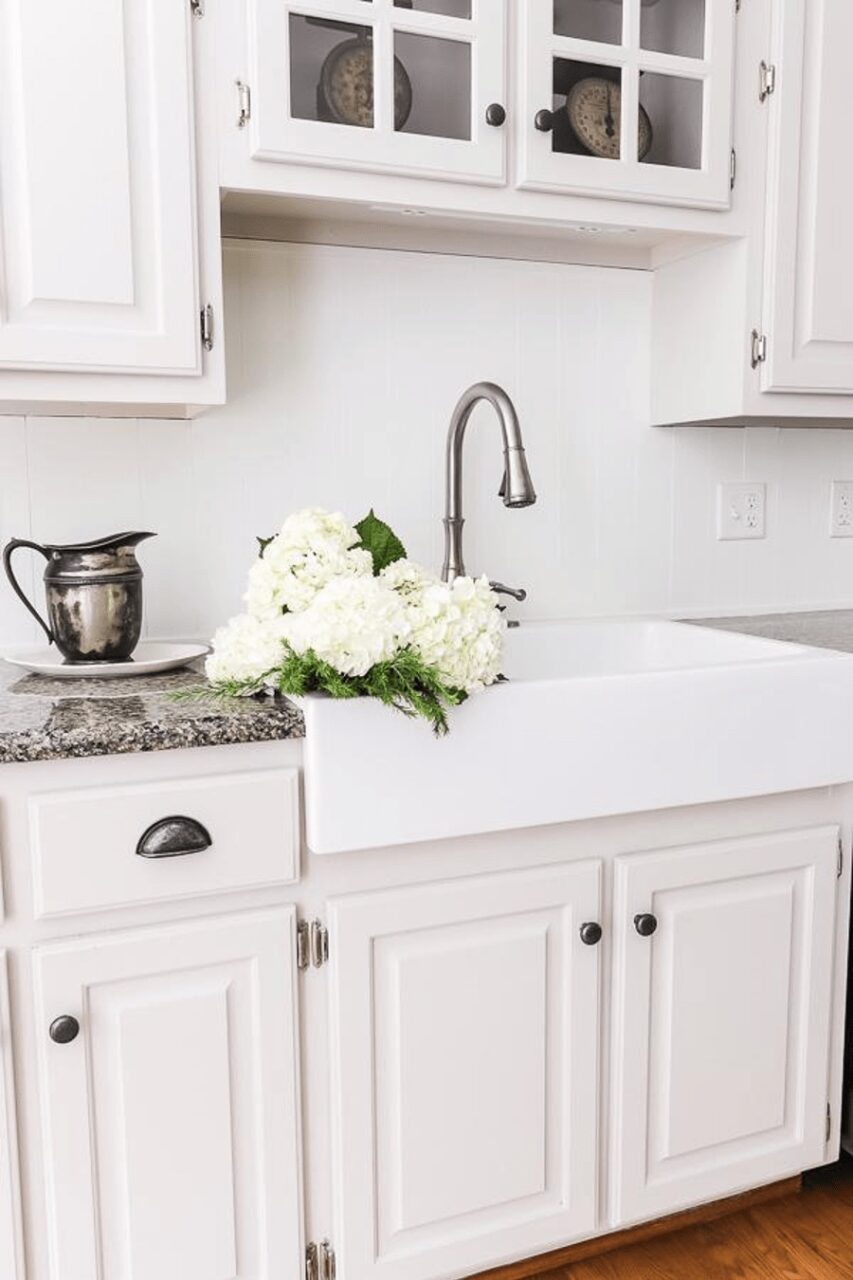 a white fireclay sink with flowers in the basin