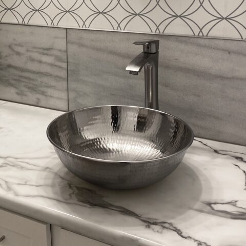 A hand hammered nickel vessel bathroom sink.