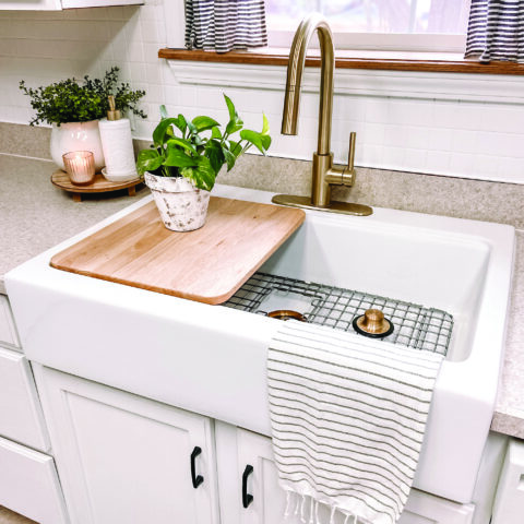 wooden cutting board in workstation sink
