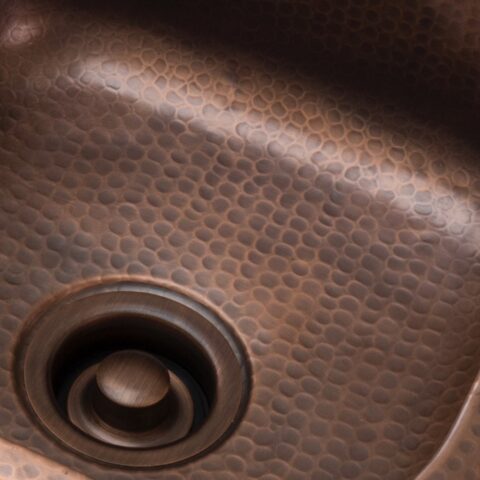 An antique brown kitchen sink disposal drain.