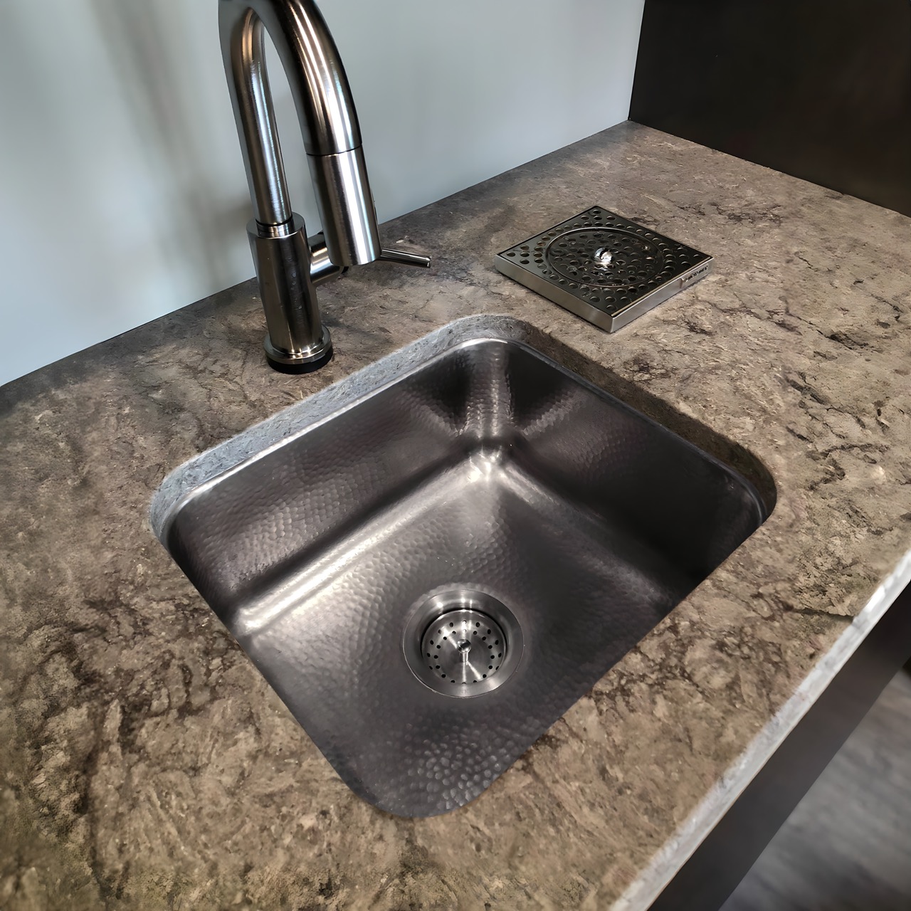 A square hand hammered undermount stainless steel bar and prep sink