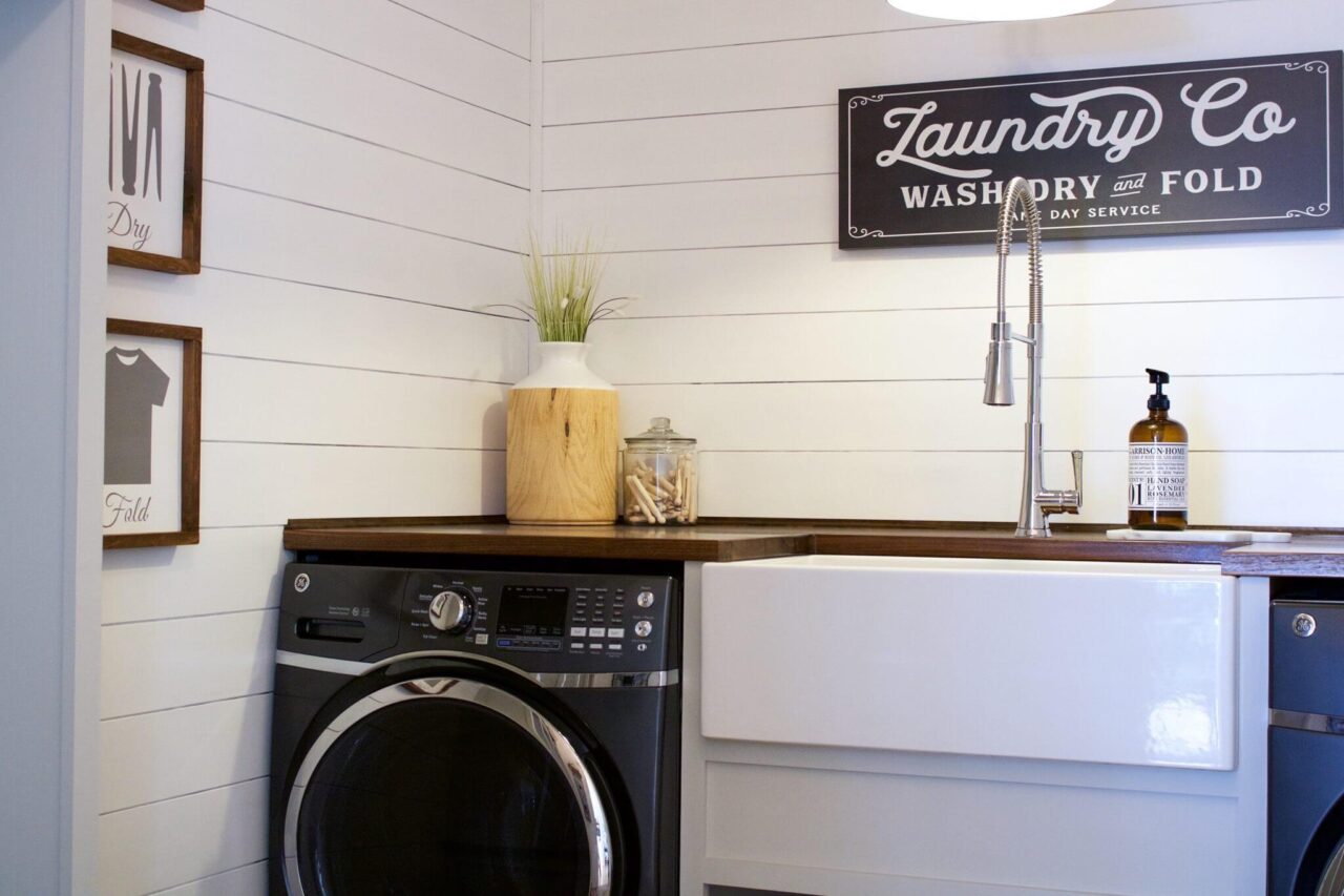 A laundry room with a farmhouse sink and a washing machine.