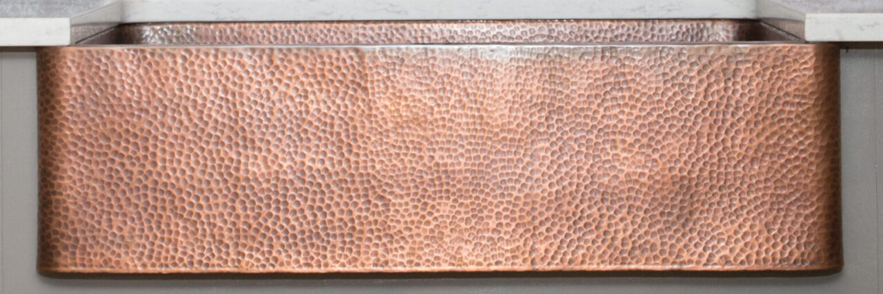 A detailed close up image of a copper kitchen sink.